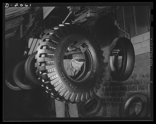 Through final inspection. Tires on an endless-crane overhead, swing through the final inspection department and spray paint booth where they are given a preservative coat of special tire paint. The tire-around-the-man is the new military tire--the non-directional. Firestone (General) Tires, Akron, O