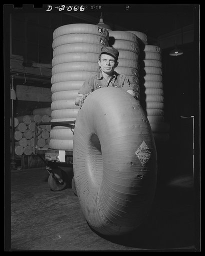 Wrapped, sealed, labeled. Ready for delivery, this finished tire carries the description and size of the tire on an outside label. May be kept for a long period when wrapped in this protective covering, but during the war emergency, most tires are sent out unwrapped because it thus saves paper, they
