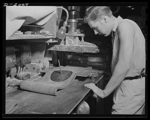 Seating the valve and seaming the tube. After each tube is snipped off at the proper length, it passes to this worker who places the open and over a sleeve, and forces the valve into position right in the center of reinforcing patch. This makes doubly sure that the tube is absolutely leak-proof. Whe