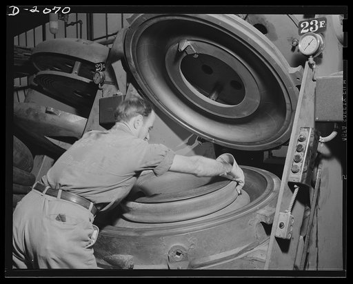 Placing the raw tube in the curing mold. This tire worker gives the tubes the same treatment his co-workers give tires; They are cured in a watch-case mold for the required length of time at the proper heat. Naturally tubes take less time than tires because they are single thickness. They are their 