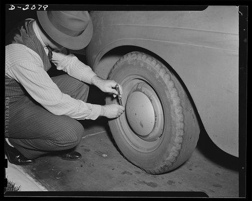One way to increase tire life--and to do your part in the saving of rubber for the forces of fighting to defend your right to drive in freedom over the roads of this democracy is to keep the pressure right. This driver isn't thinking of war, however, as he checks his tire pressure. He's just using c