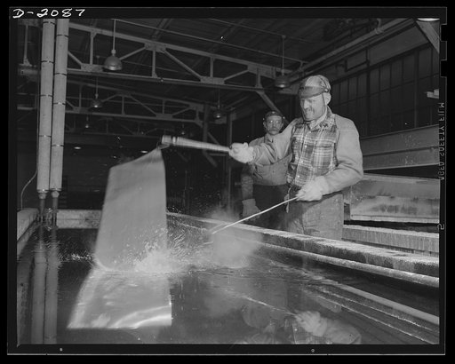 Subcontracting aircraft parts. Heat treatment is essential to develop the toughness necessary in the metal for U.S. warcraft. This worker is quenching a metal sheet which has just come from the furnace. Goodyear, Akron, Ohio