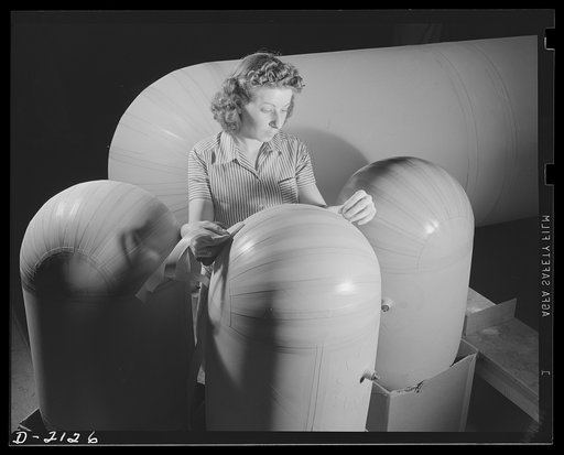 Flotation bag manufacturing. There are as many types of flotation bags as there are types of planes. In this picture; small flotation bags for insertion in tips of wings of planes which must fly over water, are shown. These bags can be inflated quickly from compressed air cylinders to support planes