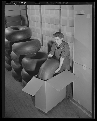 Aircraft tire manufacture. Workman packages airplane tires of type in common use on U.S. military fighter aircraft. Goodyear, Akron, Ohio