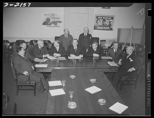 The following members and alternates attended the first meeting of the War Production Board, held January 20, 1942, in the conference room of the new Social Security Building. Seated, left to right: Leon Henderson, director, Civilian Supply Division; James Forrestal, under-ecretary of the Navy; Jess