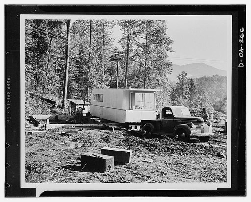Defense housing. The first section of the Tennessee Valley Authority's (TVA) experimental trailer-house is backed up onto its foundation in the mountains of North Carolina. The section is equipped with wheels on the underside, the foundation is equipped with tracks. The wheels are placed on the trac