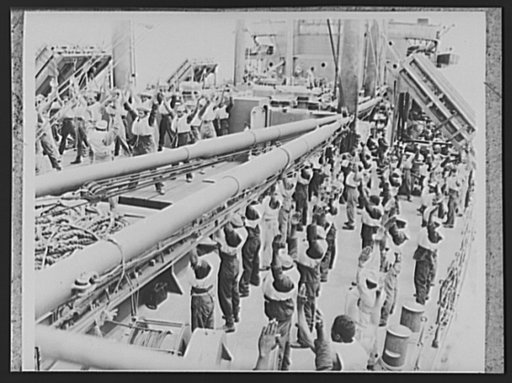 U.S. Negro troops on way to Liberia. Negro members of an American Army engineer's unit, on a transport bound for Liberia, Africa, take their daily setting up exercises on deck. The men are wearing a new light type of life preserver which allows freer movement than the older bulkier type formerly use