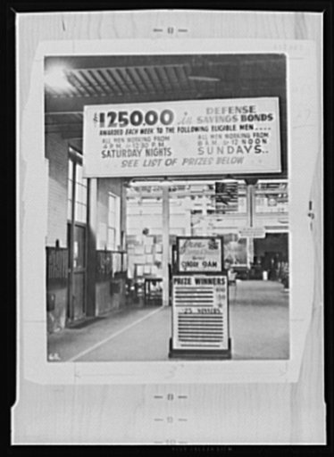 War production drive. The labor-management committee in the Minneapolis plant of the Northern Pump Company had trouble with absenteeism, especially Saturday nights and Sundays. To overcome this, door prizes were distributed among the men who worked on those shifts. This photograph shows the announce