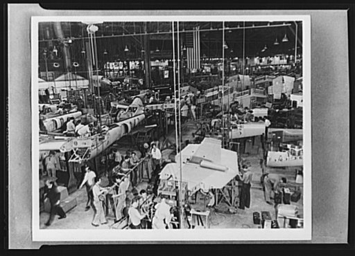 Production. Lockheed P-38 pursuit planes. "Mating" operation in the production of Lockheed P-38 pursuit planes. Previously assembled ship sections are joined together here to form the body of the plane. Feed lines from subassembly sections come to this point from three directions. Only a comparative