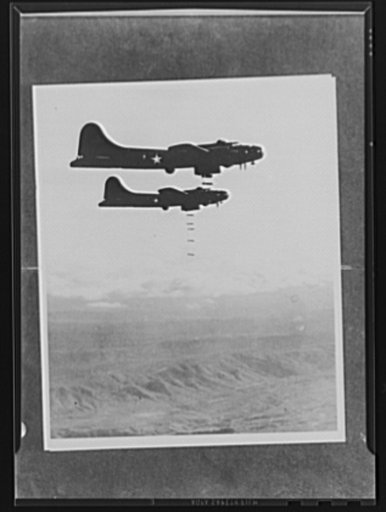Bombs away! At the proper moment the bombardiers release their load. A salvo, such as this, finds all bombs dropping in a straight line, because each of them continues, for a time, at the same forward speed it had acquired while in the plane's bomb bay. Three miles down below is the target, the obje