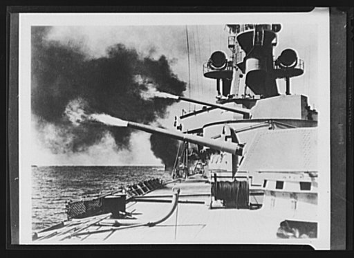 This is the Dutch cruiser "de Ruyter," firing a salvo while on manuvers from its base at Sourabaya, on the island of Java, Netherlands East Indies. The bulk of the Dutch Navy is again in the battle for democracy, basing its operations at this strongly fortified port