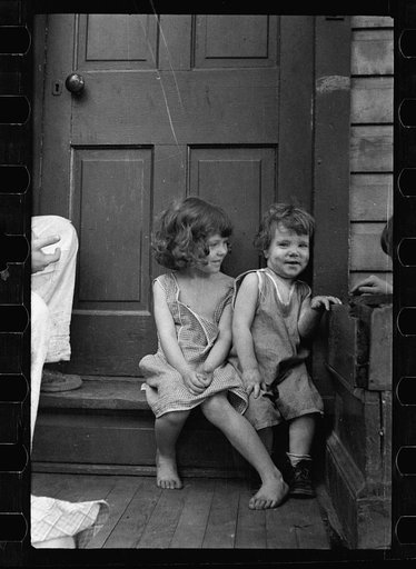 Small girls sitting in doorway of house in Georgetown, Washington, D.C.