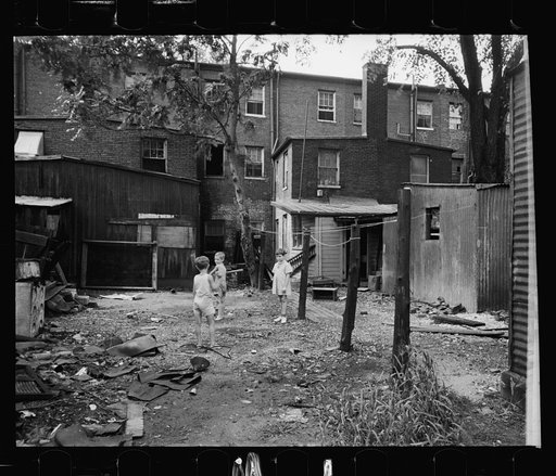 Untitled photo, possibly related to: Children in slum area, Washington, D.C. Children in their backyard in a slum area near the Capitol. This area inhabited by both black and white