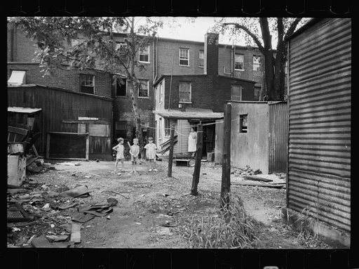Children playing in backyard in slum area near capitol. This area inhabited by both white and Negro, Washington, D.C.
