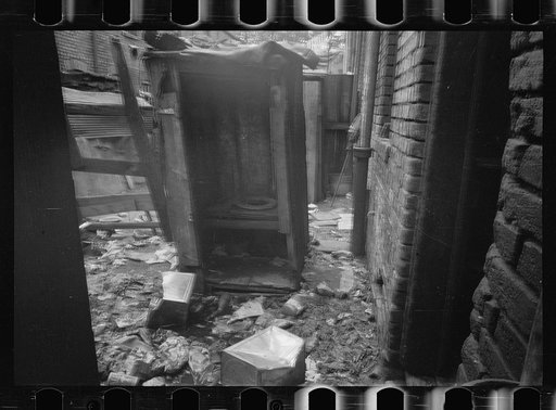 Untitled photo, possibly related to: Privy near Capitol, Washington, D.C. This outbuilding leaks and drains on land about it. Negro inhabitants appear oblivious to it all. No door to this privy, but a sheet of canvas which is seldom used