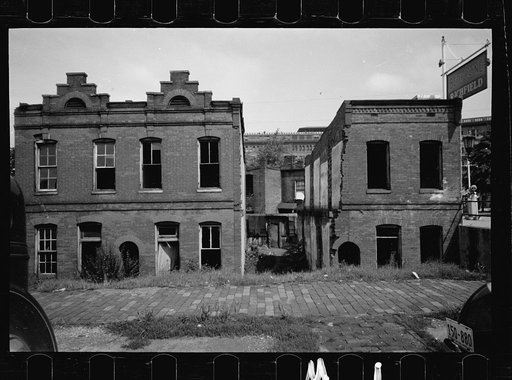 Ruins of old brick structures, Washington, D.C. Sections of these buildings are still inhabited. The Government Printing Office is shown in the background. This section of Washington has some of the worst housing conditions in the District and for the most part, is completely Negro.  None of these h