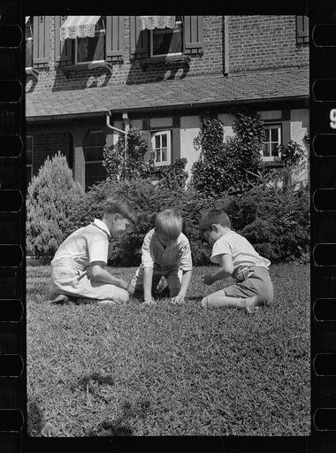 Healthy children at play on the front lawn of one of Washington's better housing sections. These houses have both sweeping front lawns and clean backyards