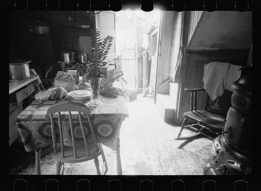 Hovel home of two Negro families, Washington, D.C. Near ice chest is the privy, although unseen in this picture. A recent relief visit accounts for the food on the table