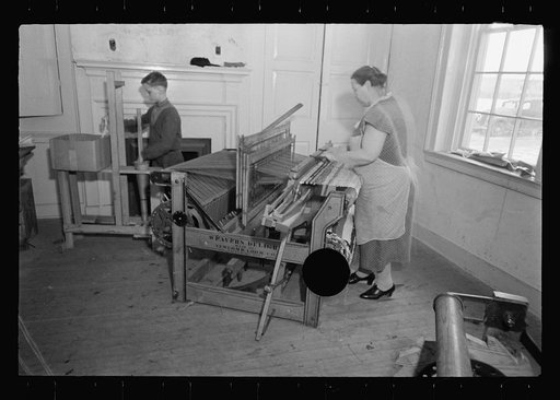 Untitled photo, possibly related to: Homewoven dress and rug, Westmoreland Homesteads, Mount Pleasant, Westmoreland County, Pennsylvania. Westmoreland homesteader wearing dress of cloth woven herself on homestead looms and working on rug woven by her homestead loom
