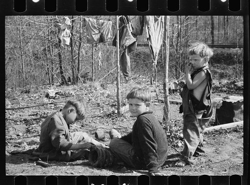 Three of the family of nine living in field in rough board covering built on old Ford truck chassis on U.S. Route 70, between Camden and Bruceton, Tennessee. Their water supply was an open creek running near state highway