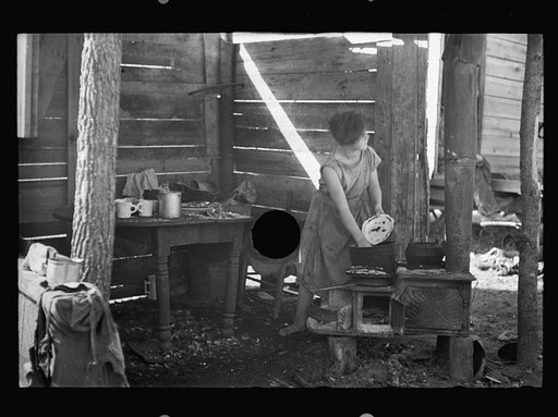 Untitled photo, possibly related to: Twelve-year old girl of family of nine, cooking meal in rude, open lean-to near hut, Tennessee