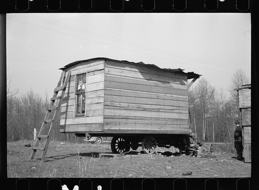 This one-room hut built of rough lumber over the chassis of an abandoned Ford truck was the housing provided by a landlord for an illiterate wood-cutter, with a wife and seven children. Found on U.S. Route 70 between Camden and Bruceton, Tennessee, near Tennessee River.  Family of nine lived and sle