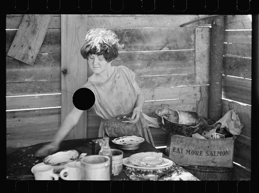 Untitled photo, possibly related to: Twelve-year old girl of family of nine, cooking meal in rude, open lean-to near hut, Tennessee