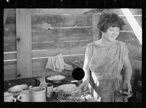 Untitled photo, possibly related to: Twelve-year old girl of family of nine, cooking meal in rude, open lean-to near hut, Tennessee