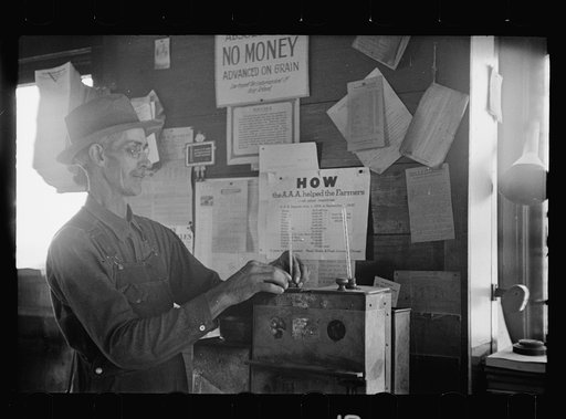 Testing the quality of corn at grain elevator before price is decided upon for the farmer, near Gibson City, Illinois