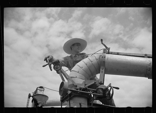 Clover farmer on seed threshing machine, St. Charles Parish, Louisiana