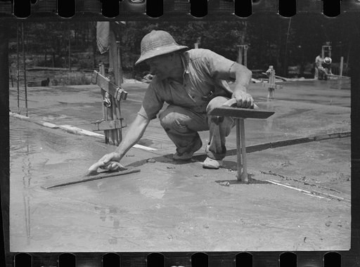 Untitled photo, possibly related to: Worker leveling cement floor, Greenbelt, Maryland