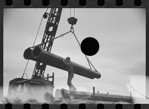 Untitled photo, possibly related to: Unloading pipe with crane, Greenbelt, Maryland