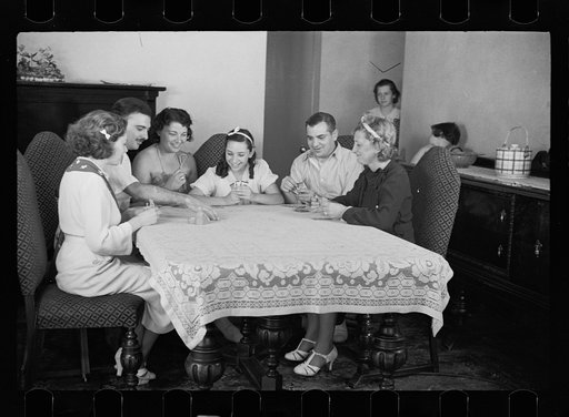 Family group playing cards in one of the new homes on the Hightstown Project, New Jersey
