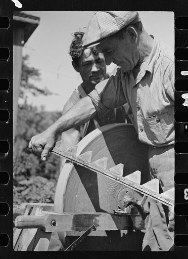 Untitled photo, possibly related to: Sharpening knife of old mowing machine on farm near Hyde Park, Vermont