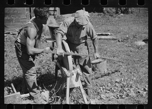 Untitled photo, possibly related to: Sharpening knife of old mowing machine on farm near Hyde Park, Vermont