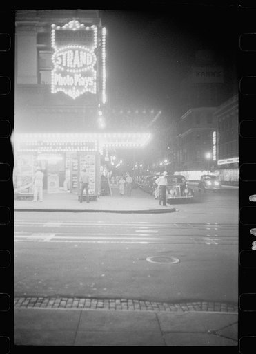Putting up movie posters at night, Washington, D.C.
