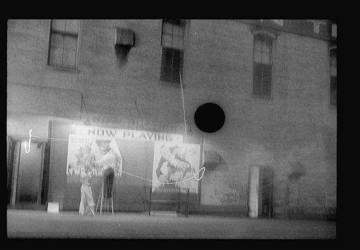 Untitled photo, possibly related to: Putting up movie posters at night, Washington, D.C.
