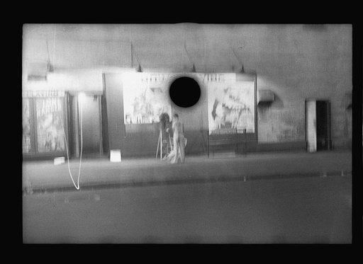 Untitled photo, possibly related to: Putting up movie posters at night, Washington, D.C.