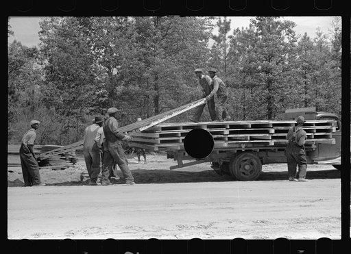 Untitled photo, possibly related to: Unloading wall of prefabricated house from truck, Roanoke Farms Project, North Carolina