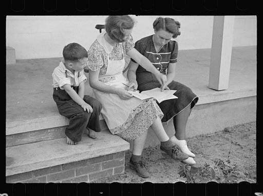 Home supervisor showing Mrs. Pope how to keep account book, Irwinville Farms, Georgia