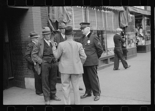 Policeman talking with group of men, South Omaha, Nebraska
