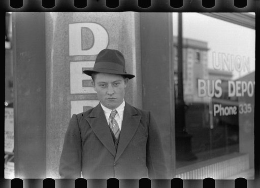 Boy in front of bus depot, Grand Island, Nebraska