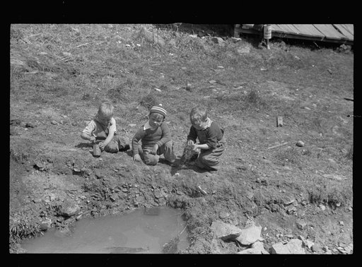 Children playing in street gutter in front of their home. Company coal town, Kempton,  West Virginia