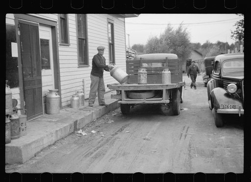 Unloading milk cans at cooperative creamery which has received a loan from the FSA (Farm Security Administration), Coleraine, Minnesota