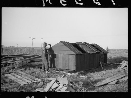 Rehabilitation client painting hog house which he built himself, Grant County, Wisconsin