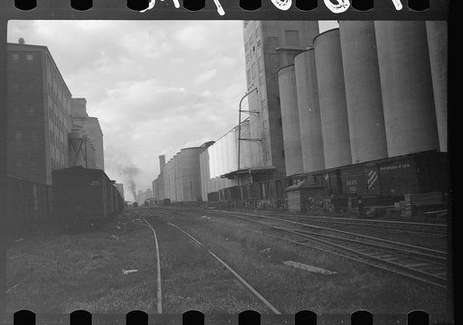 Untitled photo, possibly related to: Freight cars at grain elevator with lumber used for boarding up carloads of grain, Minneapolis, Minnesota