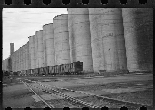 Untitled photo, possibly related to: Freight cars at grain elevator with lumber used for boarding up carloads of grain, Minneapolis, Minnesota
