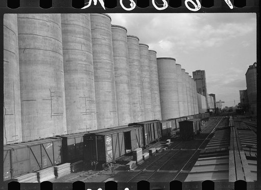 Untitled photo, possibly related to: Freight cars at grain elevator with lumber used for boarding up carloads of grain, Minneapolis, Minnesota