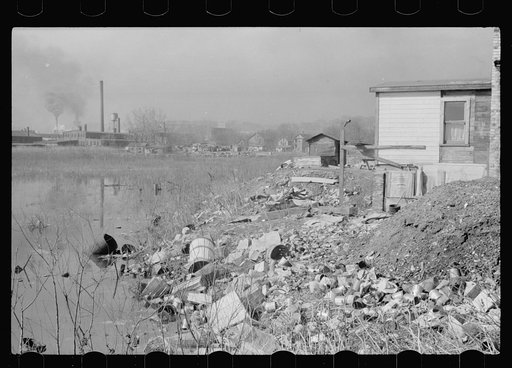 Shacktown runs along the banks of a polluted stream, Dubuque, Iowa