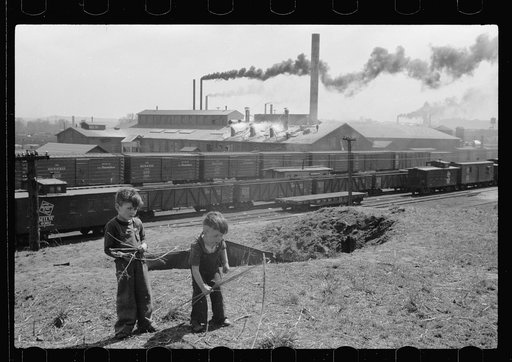 Boys playing with bows and arrows near railroad yards, Dubuque, Iowa